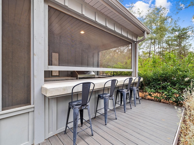 wooden deck with area for grilling and an outdoor bar