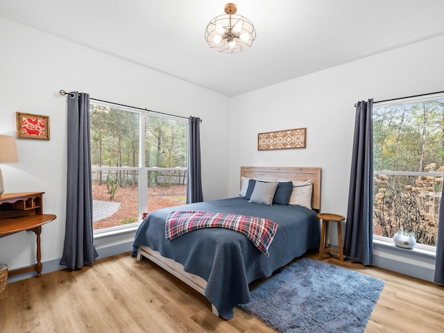 bedroom featuring a notable chandelier and light wood-type flooring