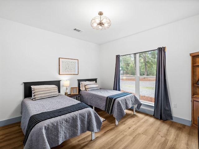 bedroom featuring a notable chandelier and light hardwood / wood-style flooring