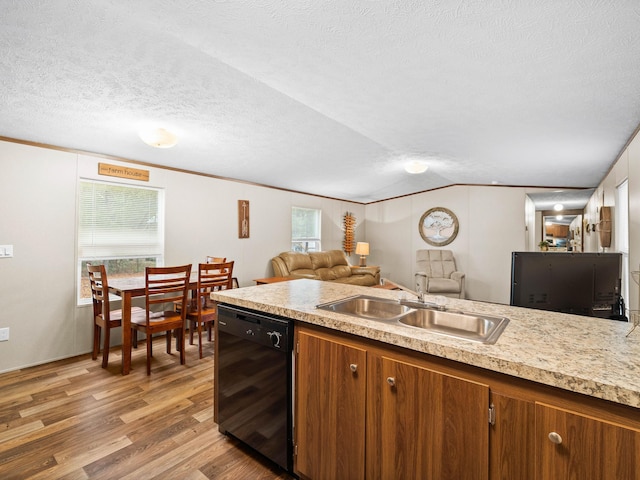 kitchen featuring lofted ceiling, sink, hardwood / wood-style floors, black dishwasher, and a textured ceiling