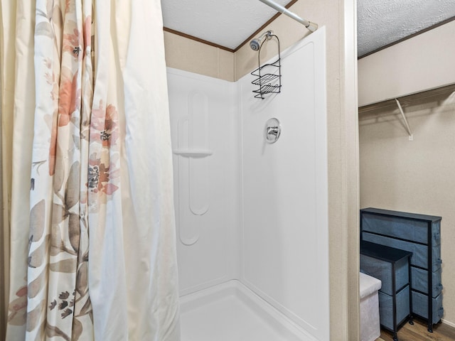 bathroom with hardwood / wood-style floors, a textured ceiling, and a shower with shower curtain