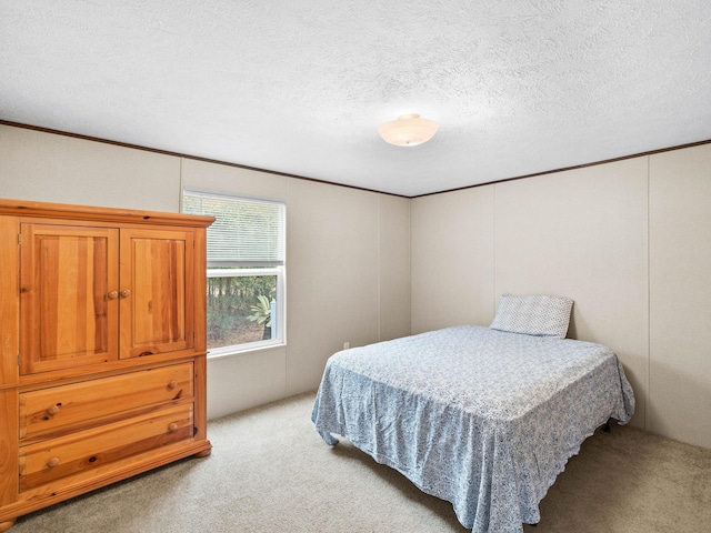 bedroom with light colored carpet and a textured ceiling