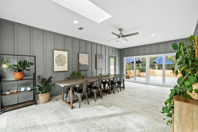 dining space with ceiling fan and a skylight