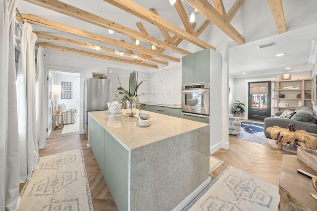 kitchen featuring light stone counters, a center island, stainless steel appliances, beam ceiling, and light parquet floors