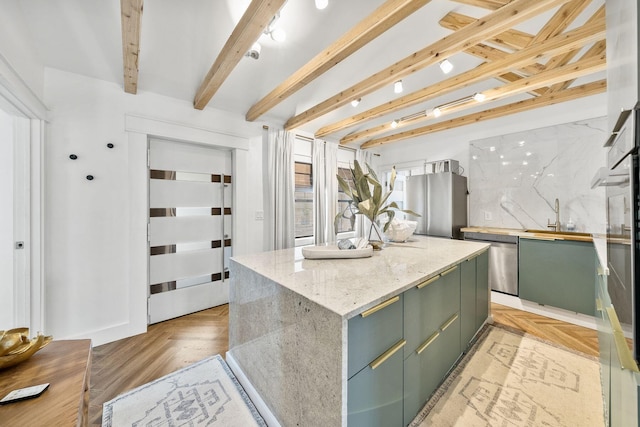 kitchen featuring a kitchen island, appliances with stainless steel finishes, tasteful backsplash, sink, and beam ceiling