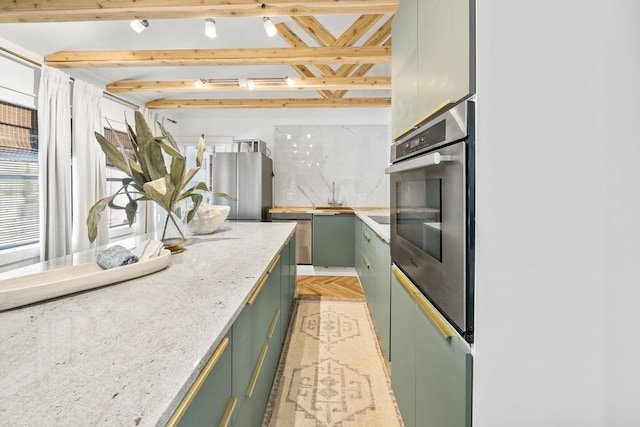 kitchen featuring sink, light stone counters, appliances with stainless steel finishes, beamed ceiling, and light parquet floors