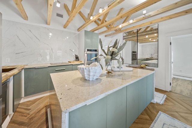 kitchen with light parquet floors, backsplash, a center island, light stone counters, and stainless steel oven