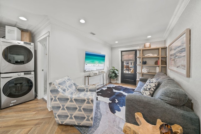 living room featuring crown molding, stacked washing maching and dryer, and light parquet floors