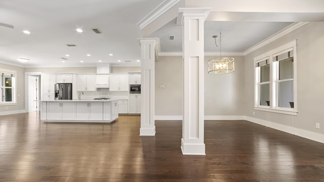 interior space featuring white cabinetry, ornamental molding, built in microwave, stainless steel fridge with ice dispenser, and ornate columns