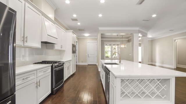 kitchen with stainless steel appliances, an island with sink, sink, and white cabinets