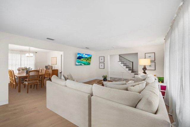 living room featuring a chandelier and light hardwood / wood-style flooring