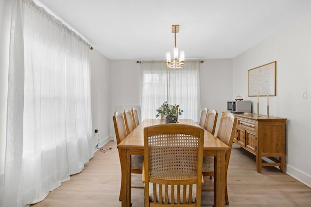 dining area with a chandelier and light hardwood / wood-style flooring