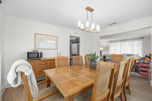 dining area featuring a chandelier and light wood-type flooring