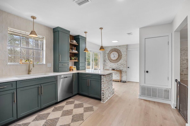 kitchen with sink, dishwasher, decorative light fixtures, kitchen peninsula, and light wood-type flooring