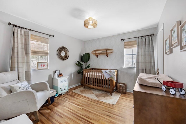 bedroom with hardwood / wood-style flooring and a crib