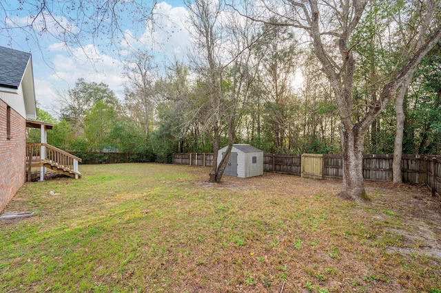 view of yard with an outbuilding, a fenced backyard, and a storage shed