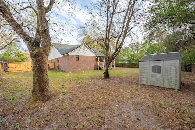 view of yard with a storage shed, an outdoor structure, and a fenced backyard