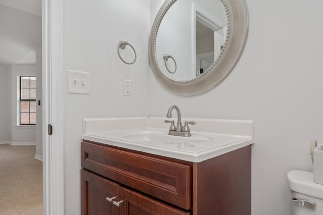 half bath featuring baseboards, vanity, and toilet