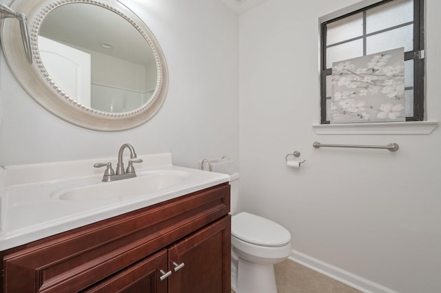 bathroom featuring toilet, tile patterned floors, baseboards, and vanity