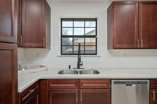 kitchen with stainless steel dishwasher, backsplash, a sink, and light stone counters
