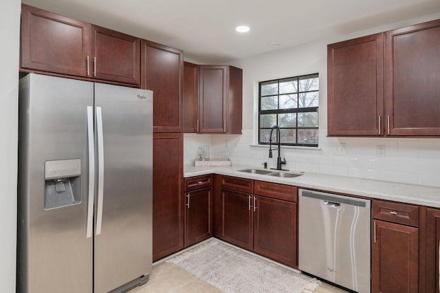 kitchen featuring appliances with stainless steel finishes, decorative backsplash, a sink, and recessed lighting
