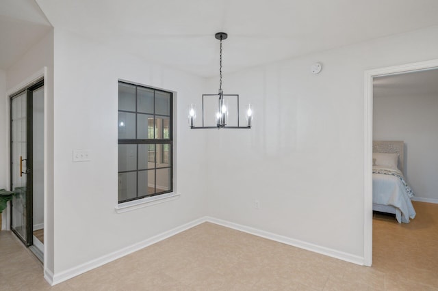 unfurnished dining area featuring baseboards and a chandelier