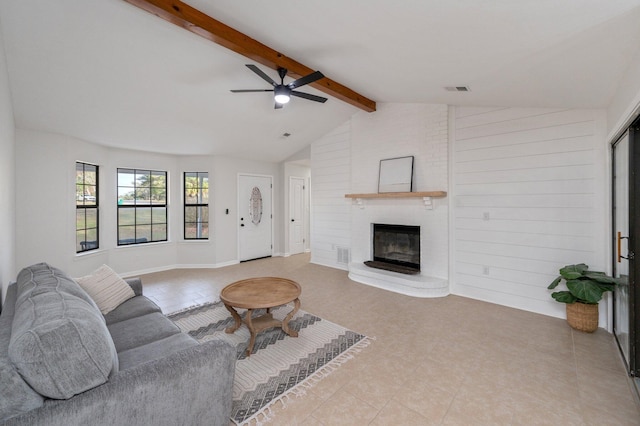 living room featuring vaulted ceiling with beams, visible vents, and a fireplace