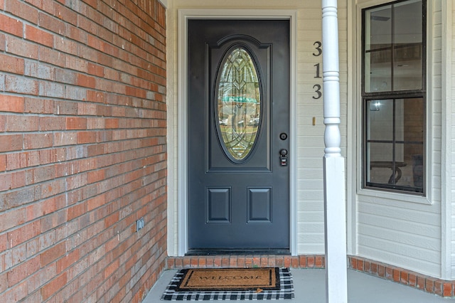 doorway to property featuring brick siding