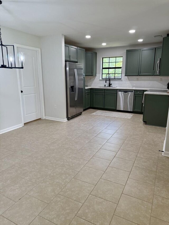 313 Ashley Dr, Crestview, FL 32536 - kitchen featuring appliances with stainless steel finishes, green cabinetry, backsplash, light countertops, and recessed lighting