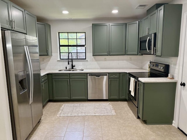313 Ashley Dr, Crestview, FL 32536 - kitchen featuring stainless steel appliances, green cabinets, decorative backsplash, light countertops, and recessed lighting