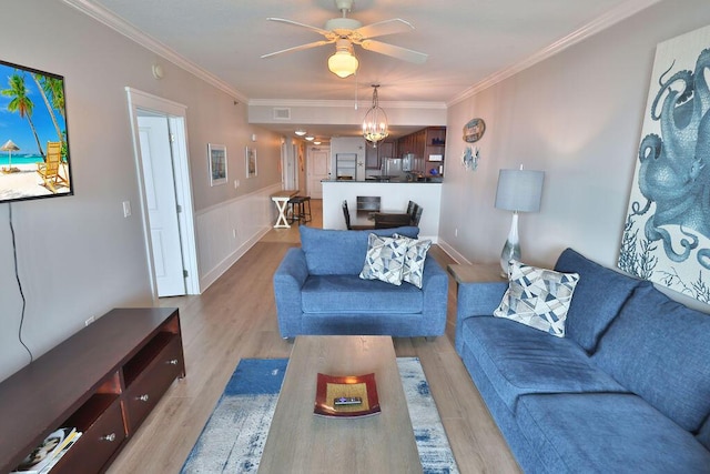 living room featuring crown molding, ceiling fan, and light wood-type flooring