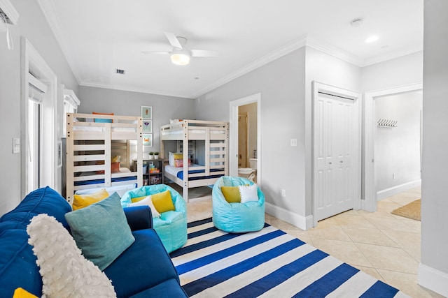 bedroom with light tile patterned floors, ornamental molding, a closet, and ceiling fan