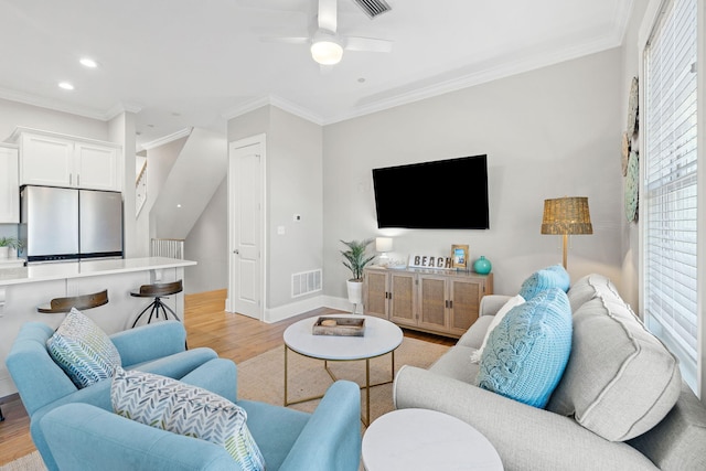 living room with crown molding, light hardwood / wood-style floors, and ceiling fan