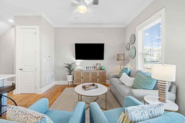 living room featuring hardwood / wood-style flooring, crown molding, and ceiling fan