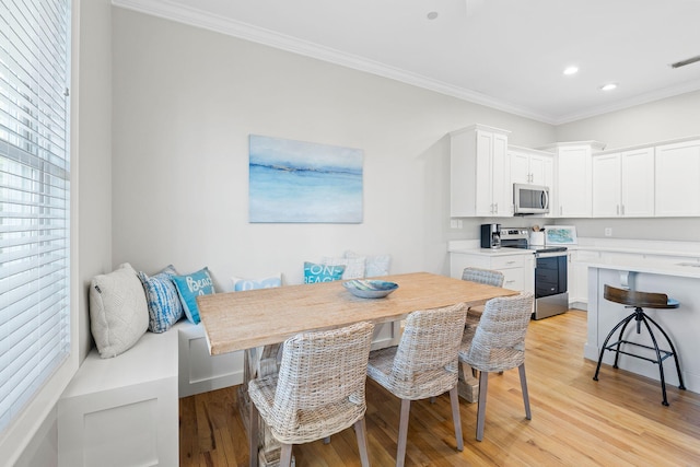 dining room with ornamental molding, light hardwood / wood-style floors, and breakfast area