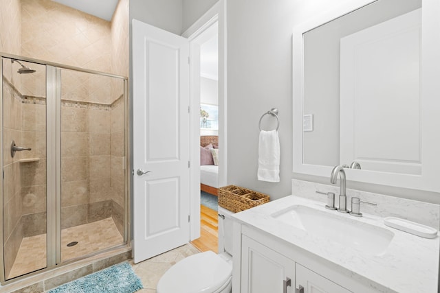 bathroom with a shower with door, vanity, and toilet