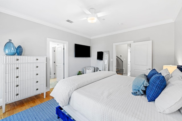 bedroom featuring crown molding, wood-type flooring, and ceiling fan