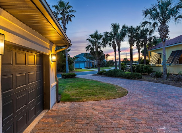 yard at dusk featuring a garage