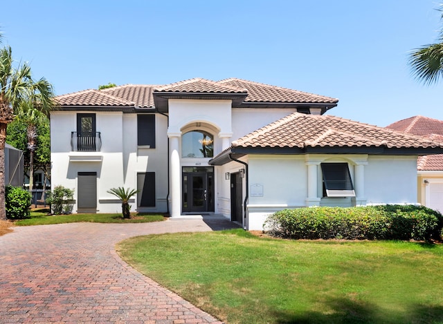 mediterranean / spanish house featuring a balcony and a front yard