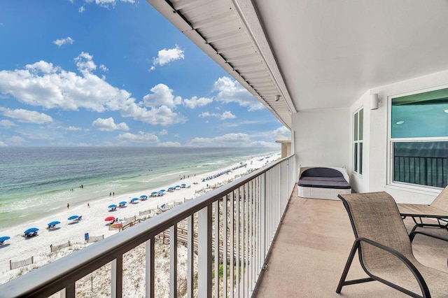 balcony featuring a view of the beach and a water view