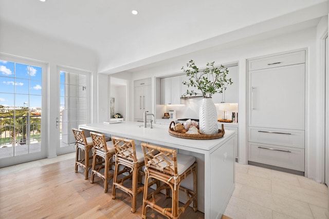 kitchen with a kitchen island with sink, sink, and a breakfast bar