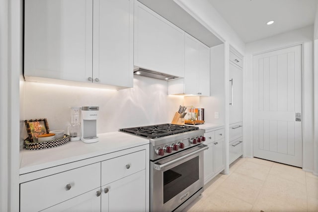 kitchen featuring luxury stove, custom exhaust hood, and white cabinets