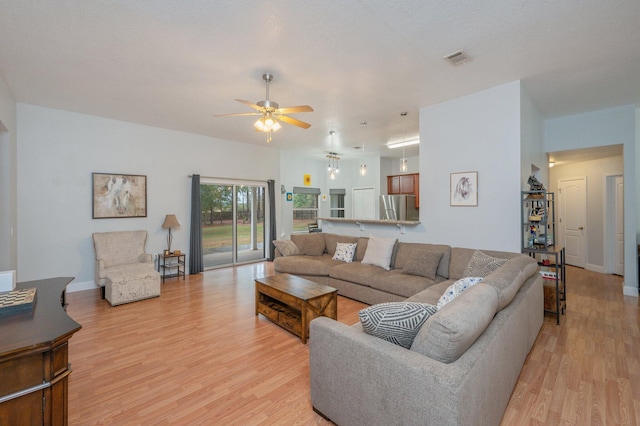 living room featuring ceiling fan and light wood-type flooring