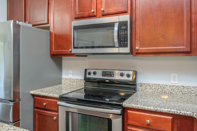 kitchen with light stone countertops and stainless steel appliances