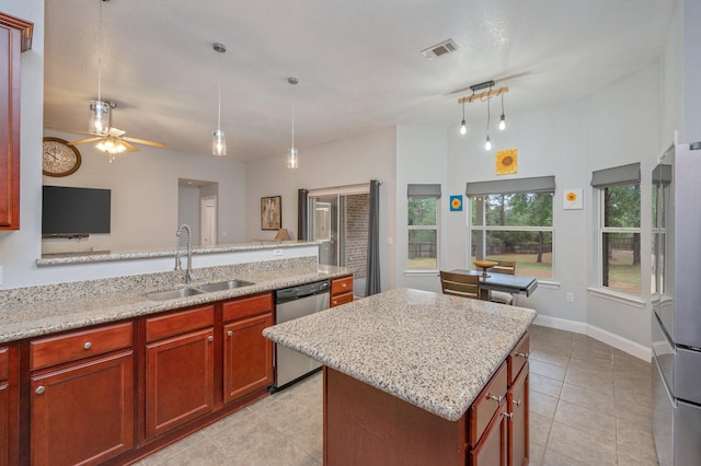 kitchen with sink, a center island, hanging light fixtures, stainless steel appliances, and light stone countertops