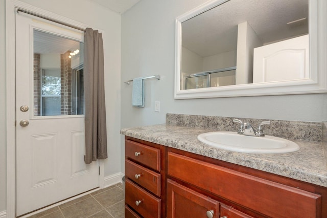 bathroom featuring vanity, tile patterned floors, and walk in shower