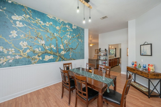 dining space featuring ceiling fan, light hardwood / wood-style flooring, and a textured ceiling