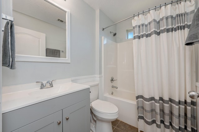 full bathroom with shower / tub combo with curtain, vanity, tile patterned flooring, and toilet