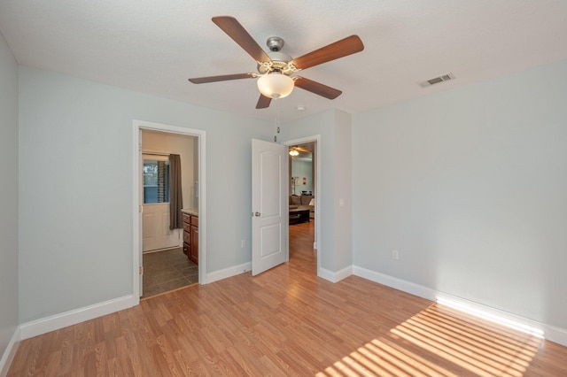 empty room with ceiling fan and light hardwood / wood-style flooring