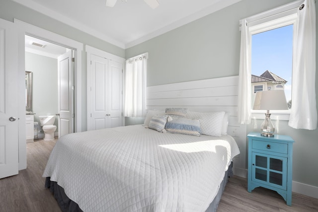 bedroom featuring ceiling fan, ensuite bathroom, hardwood / wood-style floors, and a closet